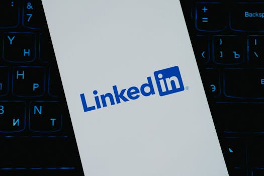 Close-up of LinkedIn logo on smartphone screen, with keyboard background.